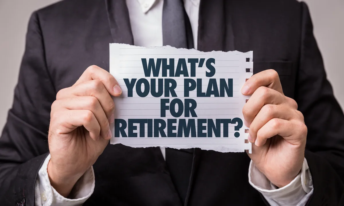 Man in a suit holding a torn notebook page that asks: What's your plan for retirement?
